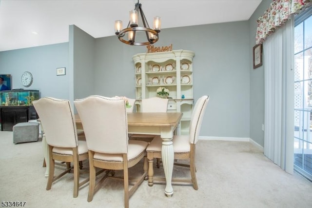 dining area featuring light carpet and a chandelier