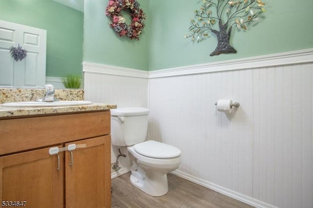 bathroom featuring vanity, toilet, and hardwood / wood-style floors