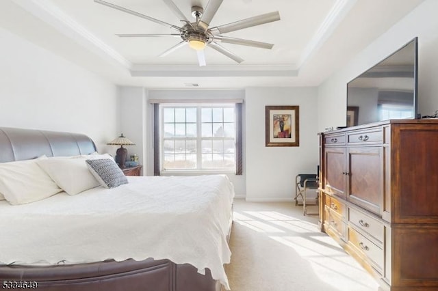 carpeted bedroom featuring a raised ceiling, ornamental molding, and ceiling fan