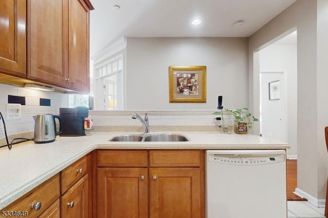 kitchen with tasteful backsplash, dishwasher, sink, and kitchen peninsula