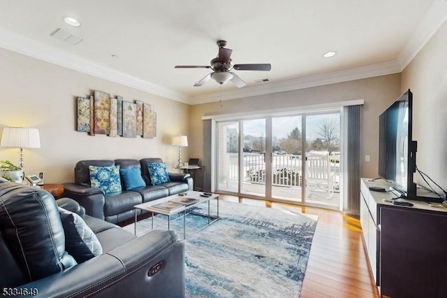 living room featuring ornamental molding, ceiling fan, and light wood-type flooring