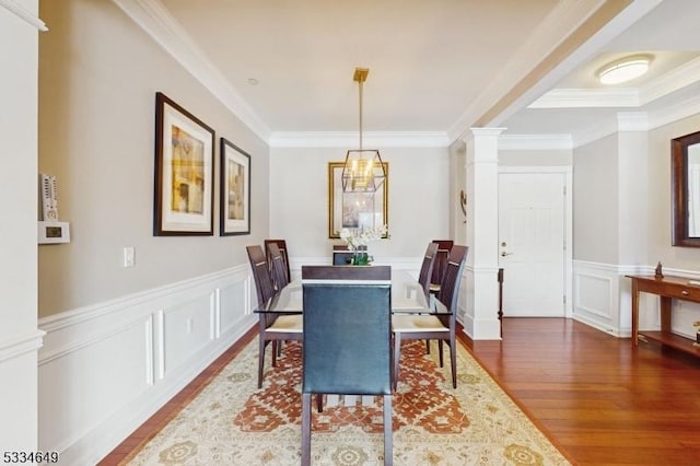 dining room featuring ornate columns, ornamental molding, and dark wood-type flooring