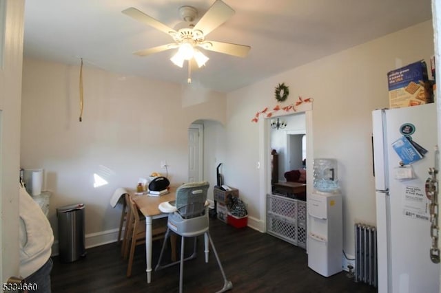 dining space featuring ceiling fan, radiator heating unit, and dark hardwood / wood-style flooring