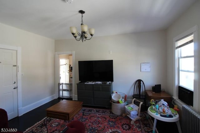 living room featuring an inviting chandelier, radiator, and dark hardwood / wood-style flooring