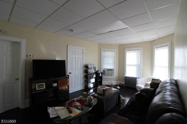 living room featuring radiator, a paneled ceiling, and cooling unit