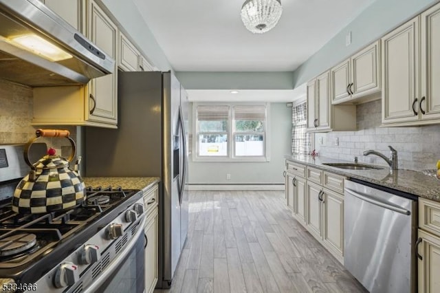 kitchen with cream cabinets, appliances with stainless steel finishes, stone countertops, and sink