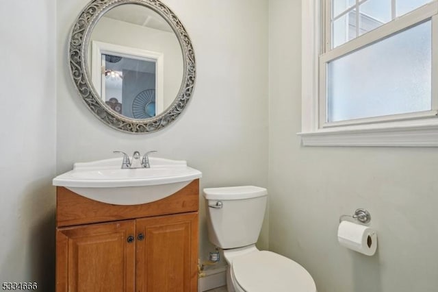 bathroom with vanity, a healthy amount of sunlight, and toilet