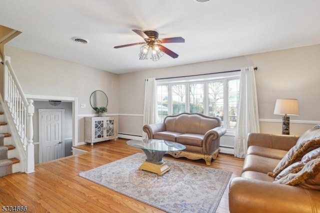 living room featuring ceiling fan, baseboard heating, and light hardwood / wood-style flooring