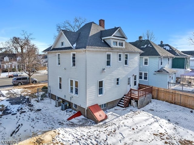 snow covered house featuring cooling unit