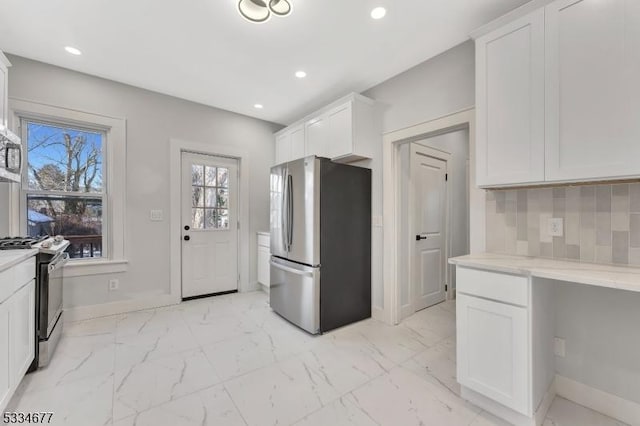 kitchen with white cabinetry, appliances with stainless steel finishes, and backsplash