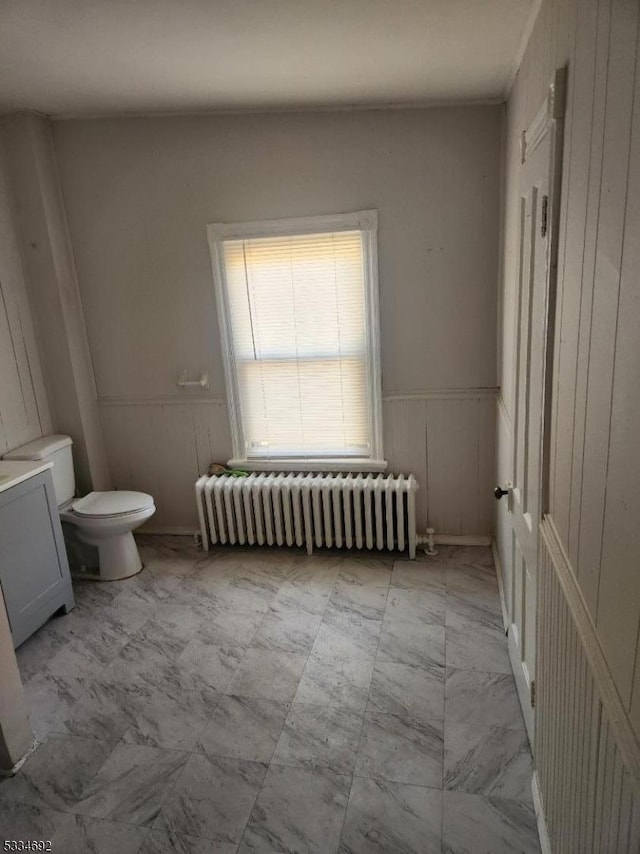 bathroom with radiator heating unit and toilet