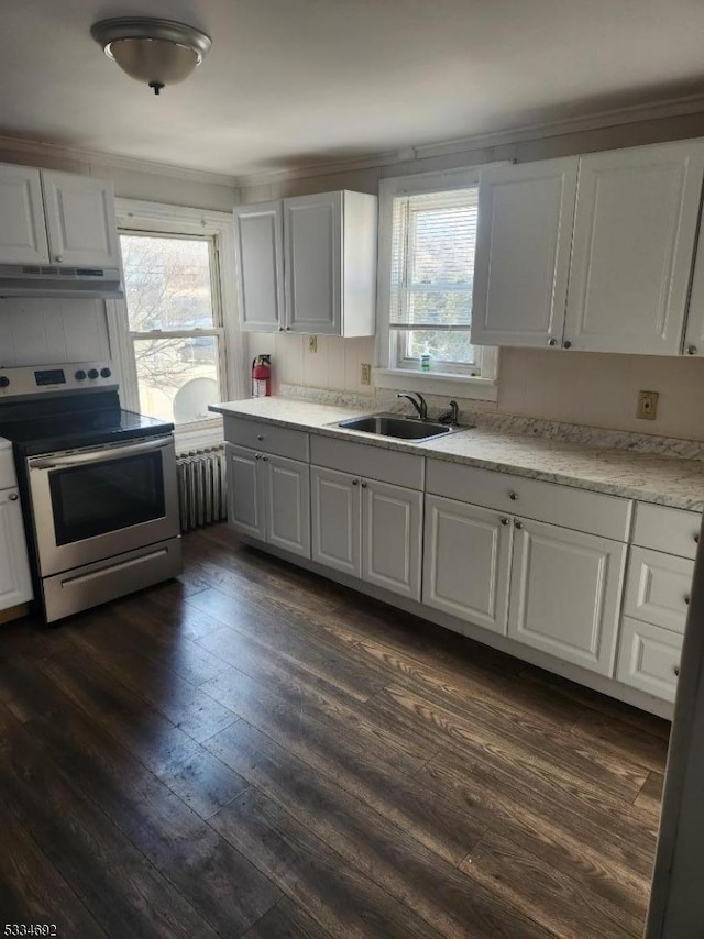 kitchen featuring sink, white cabinetry, electric range, radiator heating unit, and a wealth of natural light