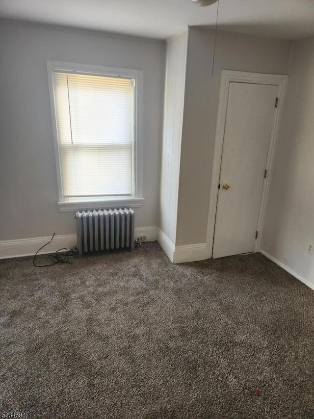 empty room with carpet floors and radiator