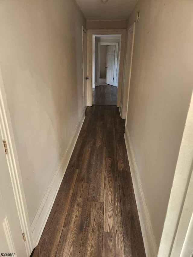 hallway with dark hardwood / wood-style floors