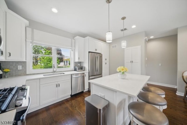 24 Stonybrook Cir, Fairfield Twp, NJ 07004 - kitchen featuring appliances with stainless steel finishes, a sink, a breakfast bar area, a kitchen island, and light countertops