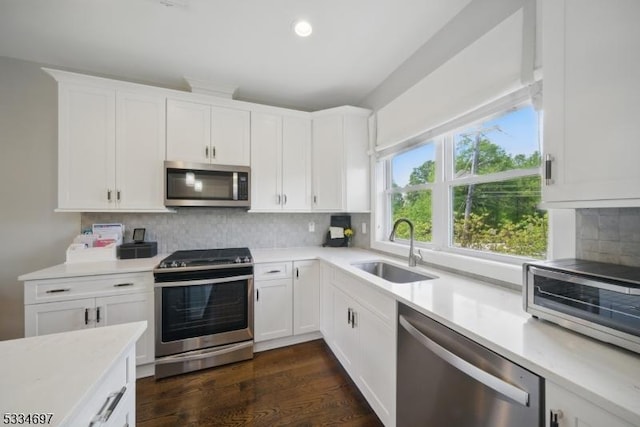 24 Stonybrook Cir, Fairfield Twp, NJ 07004 - kitchen featuring appliances with stainless steel finishes, a sink, light countertops, white cabinetry, and backsplash