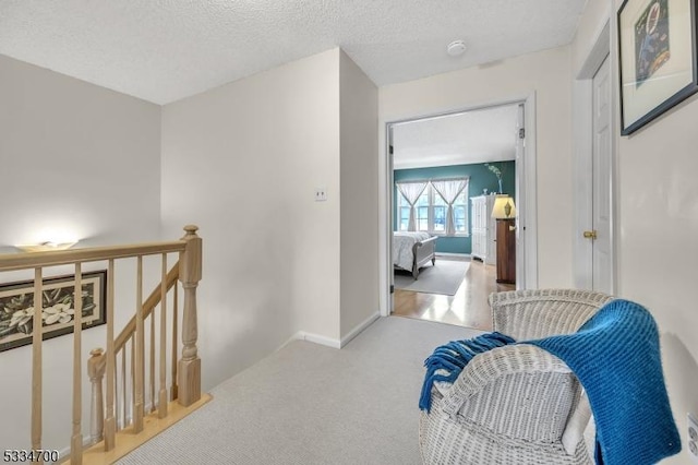 hall featuring a textured ceiling and carpet