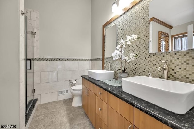 bathroom featuring tile walls, tile patterned flooring, vanity, toilet, and a shower with door