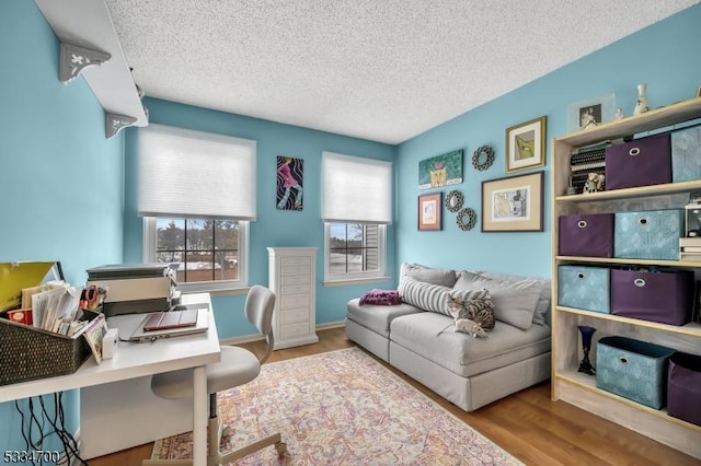 sitting room with light hardwood / wood-style floors and a textured ceiling