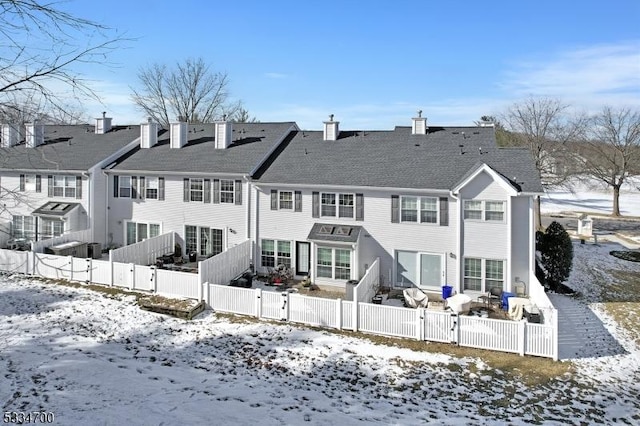 view of snow covered back of property