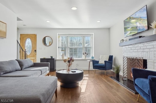 living room with wood-type flooring and a fireplace