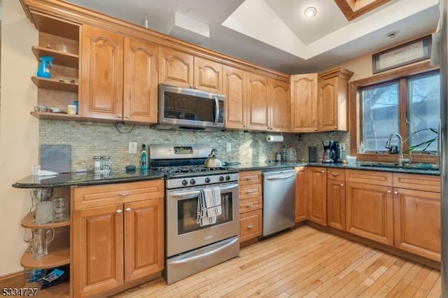 kitchen featuring appliances with stainless steel finishes, sink, dark stone countertops, and decorative backsplash