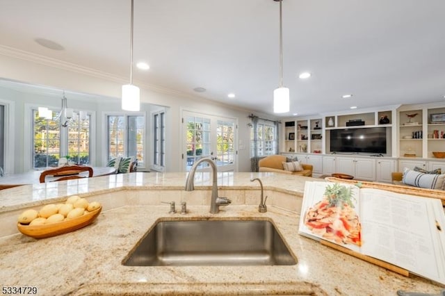 kitchen featuring ornamental molding, sink, pendant lighting, and french doors