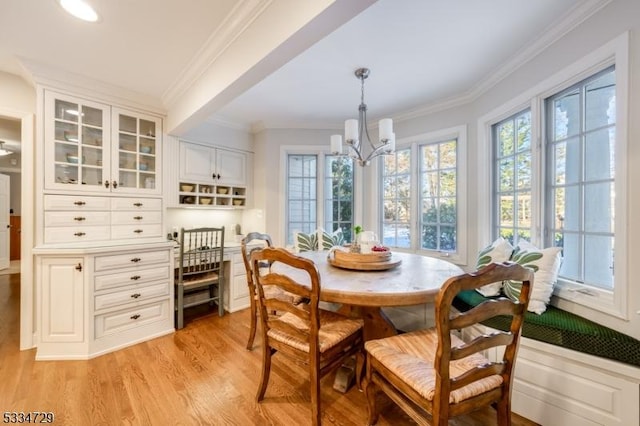 dining space with breakfast area, a notable chandelier, crown molding, and light wood-type flooring