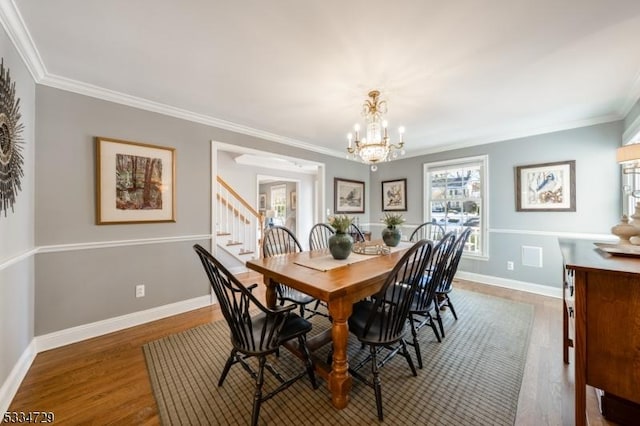 dining room featuring dark hardwood / wood-style flooring, crown molding, and a chandelier