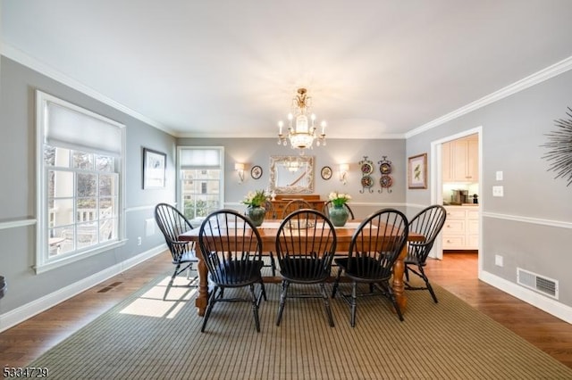 dining room featuring ornamental molding, hardwood / wood-style floors, and a chandelier