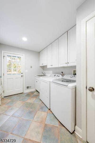 washroom featuring cabinets, washer and dryer, and sink