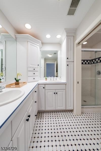 bathroom featuring vanity and a shower with shower door