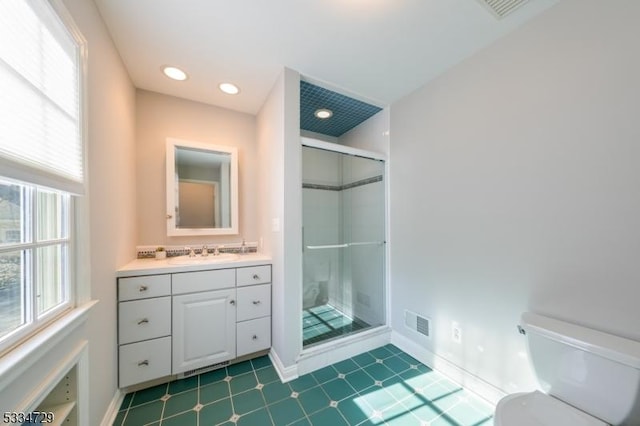 bathroom with a shower with door, vanity, and toilet