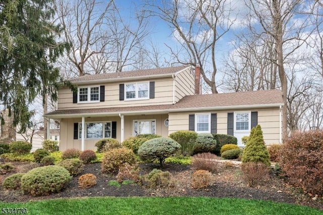 traditional home with a chimney and a shingled roof