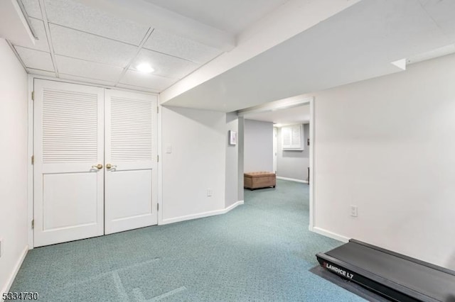 finished below grade area with carpet flooring, baseboards, and a drop ceiling