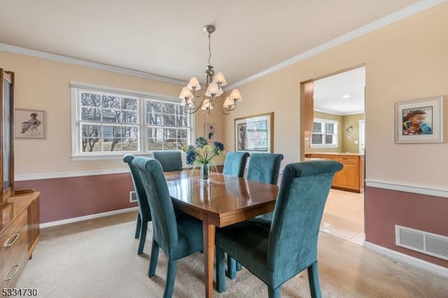 dining room featuring visible vents, crown molding, baseboards, light colored carpet, and an inviting chandelier