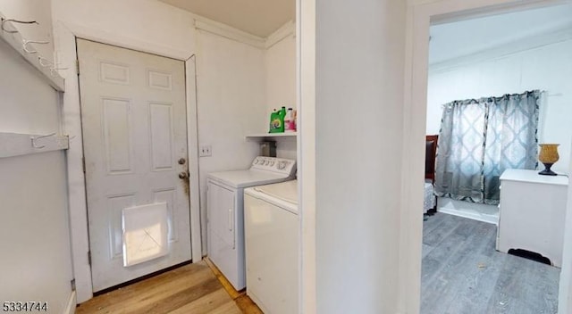 clothes washing area with separate washer and dryer and light hardwood / wood-style floors