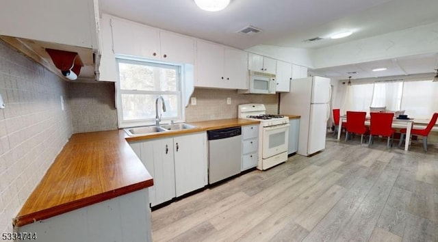 kitchen with sink, white cabinets, decorative backsplash, white appliances, and light hardwood / wood-style flooring