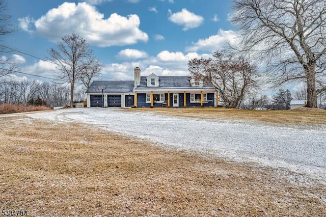 cape cod house featuring a garage and covered porch