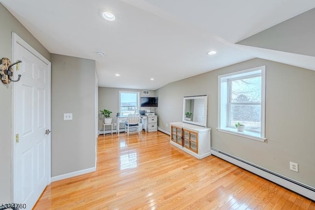 bonus room with a baseboard radiator, lofted ceiling, and light hardwood / wood-style flooring