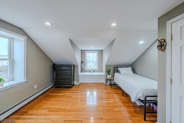 bedroom with a baseboard radiator, vaulted ceiling, and light wood-type flooring