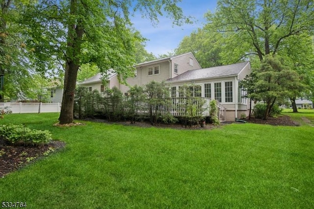 rear view of property featuring a deck and a sunroom