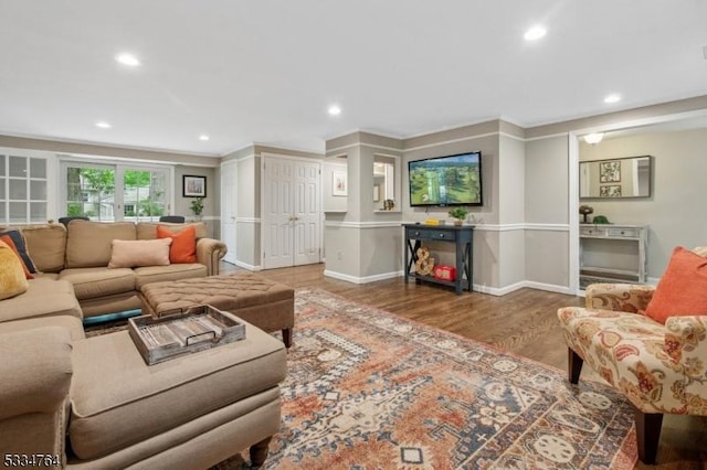 living area with recessed lighting, wood finished floors, baseboards, and ornamental molding