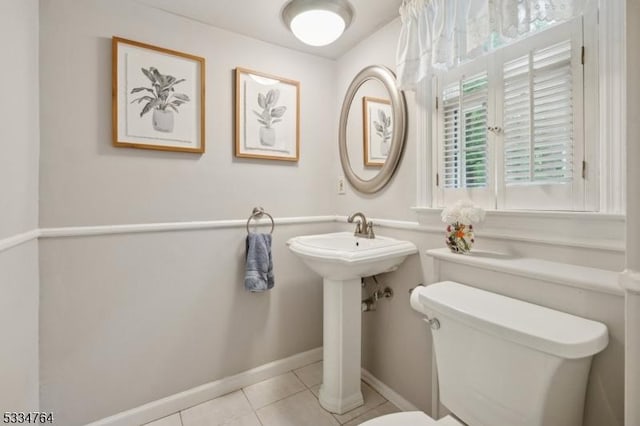 half bath featuring toilet, tile patterned flooring, and baseboards