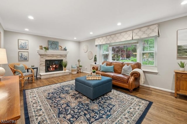 living area with recessed lighting, crown molding, a fireplace, wood finished floors, and baseboards