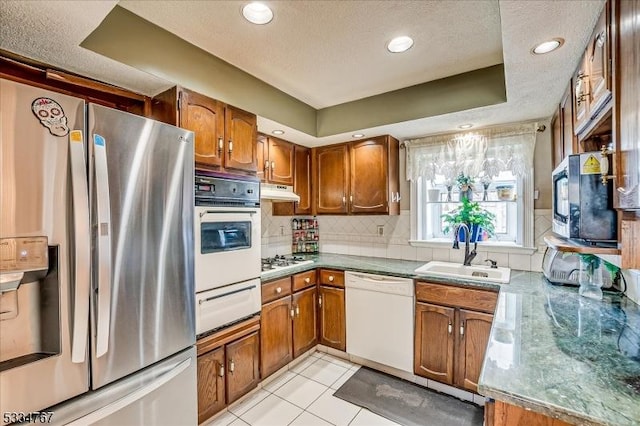 kitchen featuring sink, stainless steel appliances, tasteful backsplash, a textured ceiling, and light tile patterned flooring