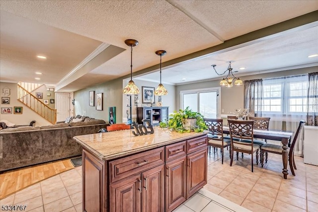 kitchen featuring hanging light fixtures, crown molding, and light tile patterned floors