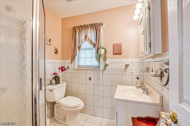 bathroom with tile patterned flooring, vanity, tile walls, and toilet