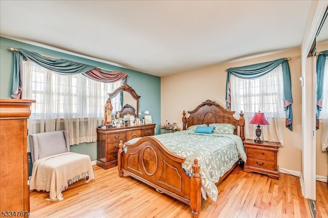 bedroom with multiple windows and light hardwood / wood-style floors