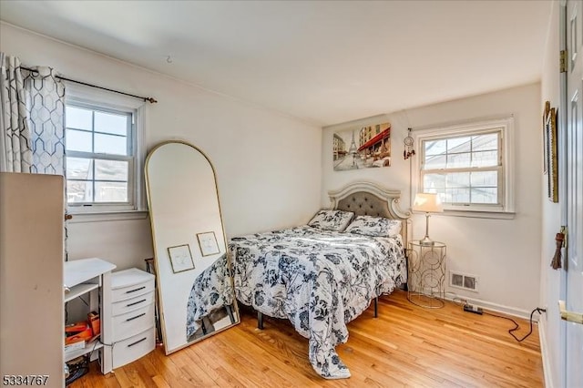 bedroom with multiple windows and light wood-type flooring